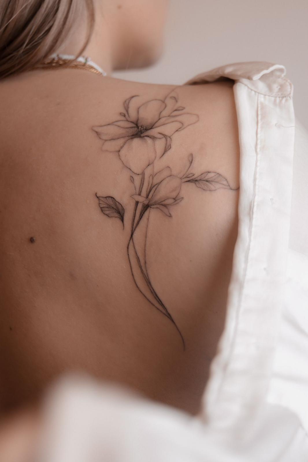 Florale Fineline Tattoo Stuttgart – Magnolien am Schulterblatt von Pure Black Art Thu Tieu